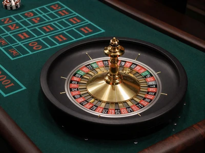Goldenes Roulette-Rad auf dunklem Filz mit t&uuml;rkisfarbenem Einsatzraster - Roulette bei Cleobetra Casino